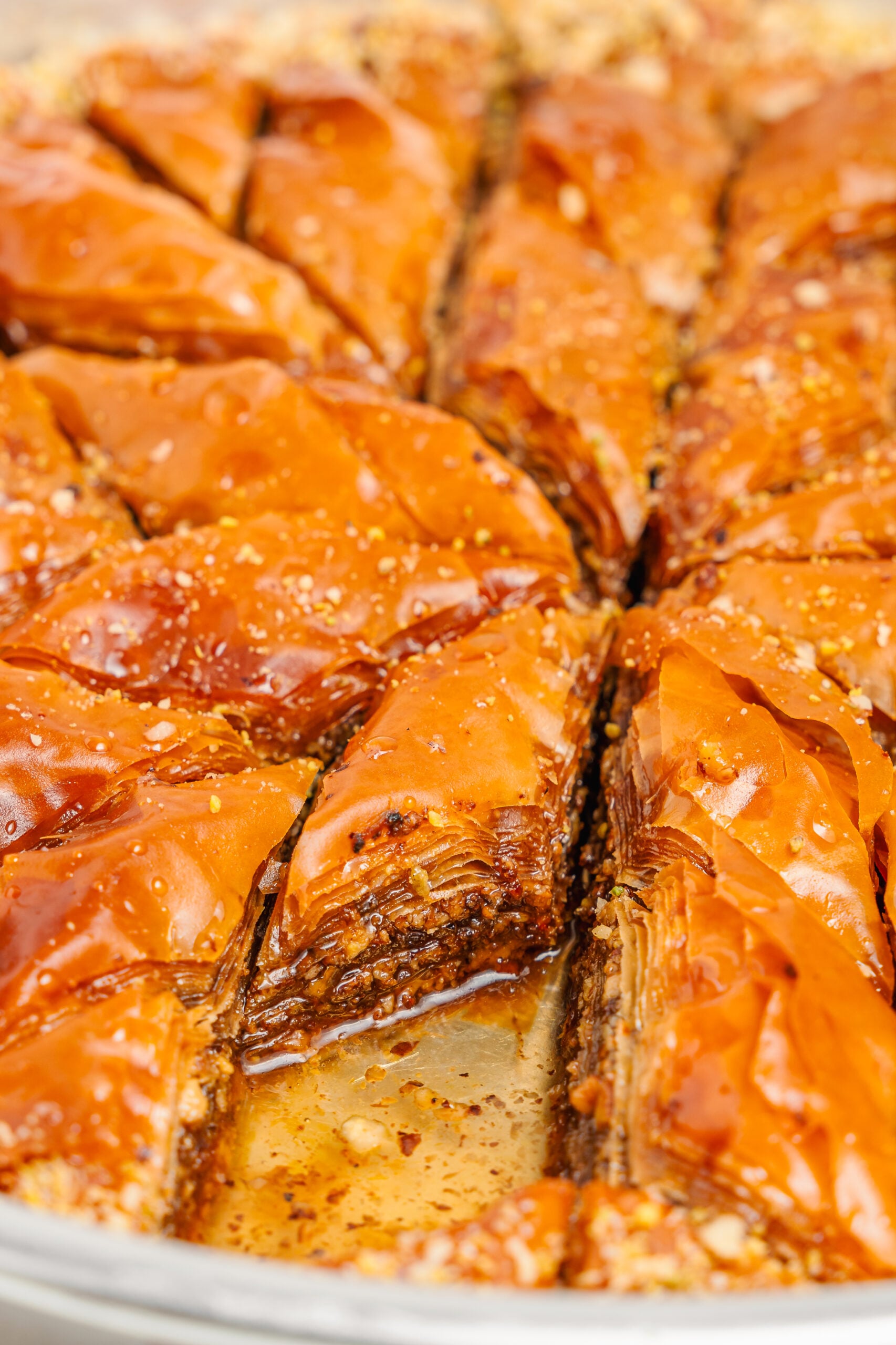 Pistachio baklava close up - Catherine Zhang Close up of glossy pistachio baklava diamonds with syrup pooling between the cuts