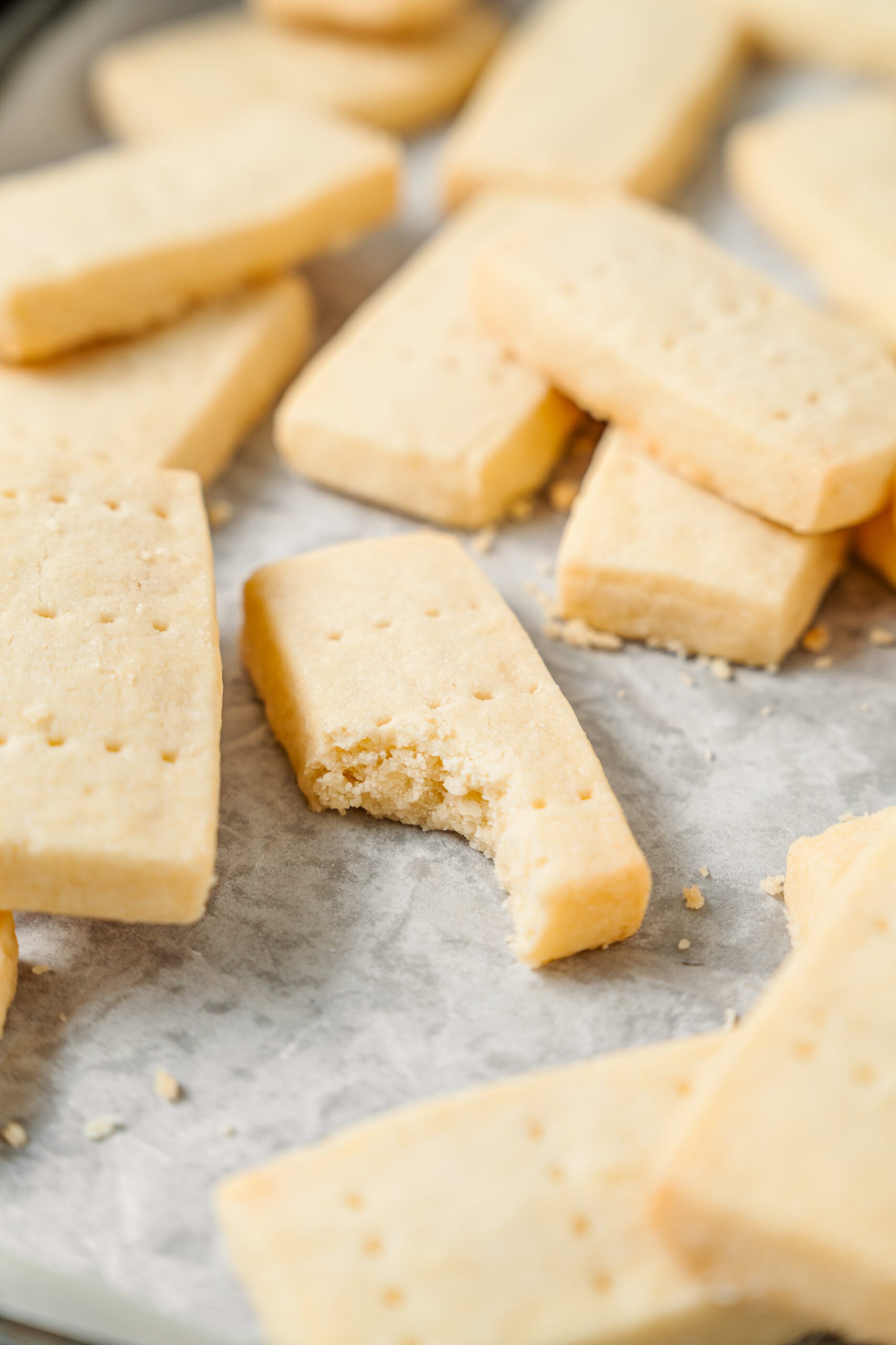 A shortbread cookie finger with a bite taken out of it, close up - Catherine Zhang A shortbread cookie finger with a bite taken out of it, close up