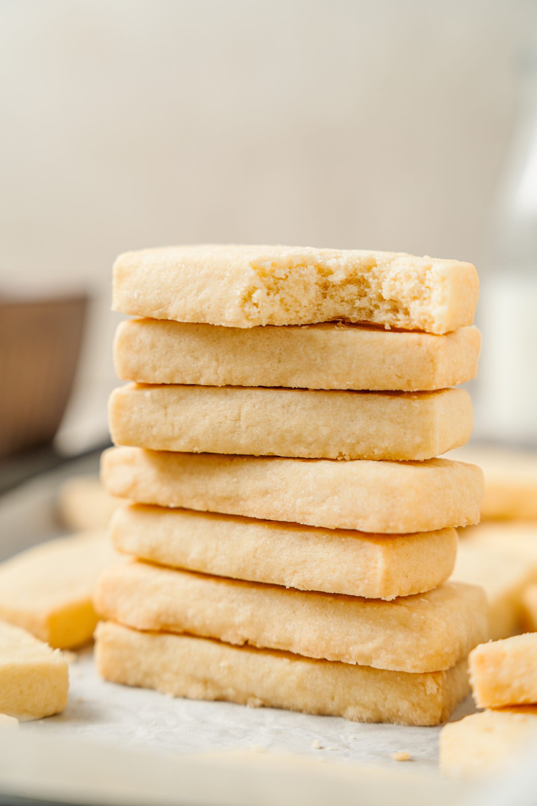 A stack of shortbread cookies with the top one broken open to show the sandy crumb - Catherine Zhang A stack of shortbread cookies with the top one broken open to show the sandy crumb