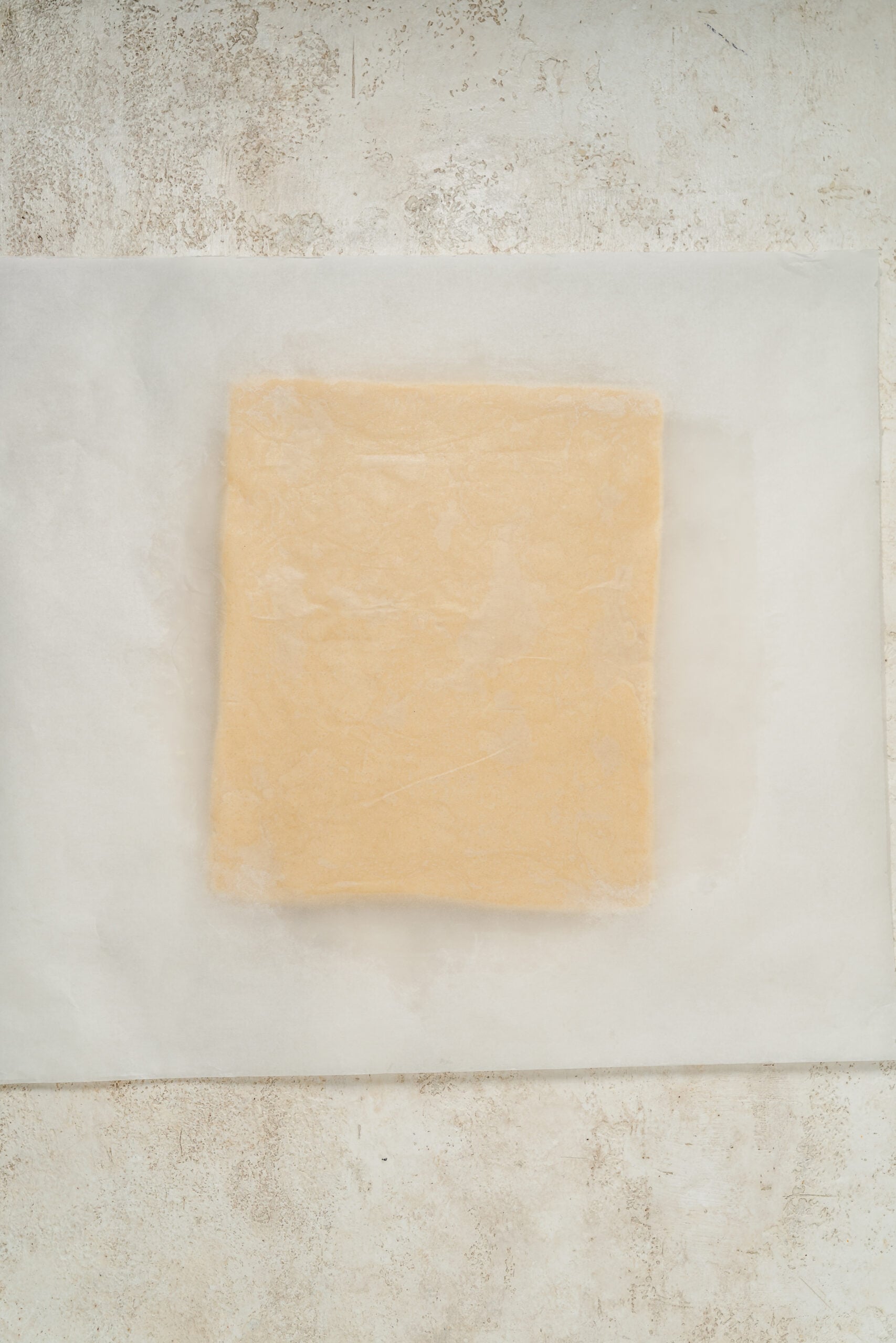 Shortbread dough rolled to an even thickness between two sheets of baking paper - Catherine Zhang Shortbread dough rolled to an even thickness between two sheets of baking paper
