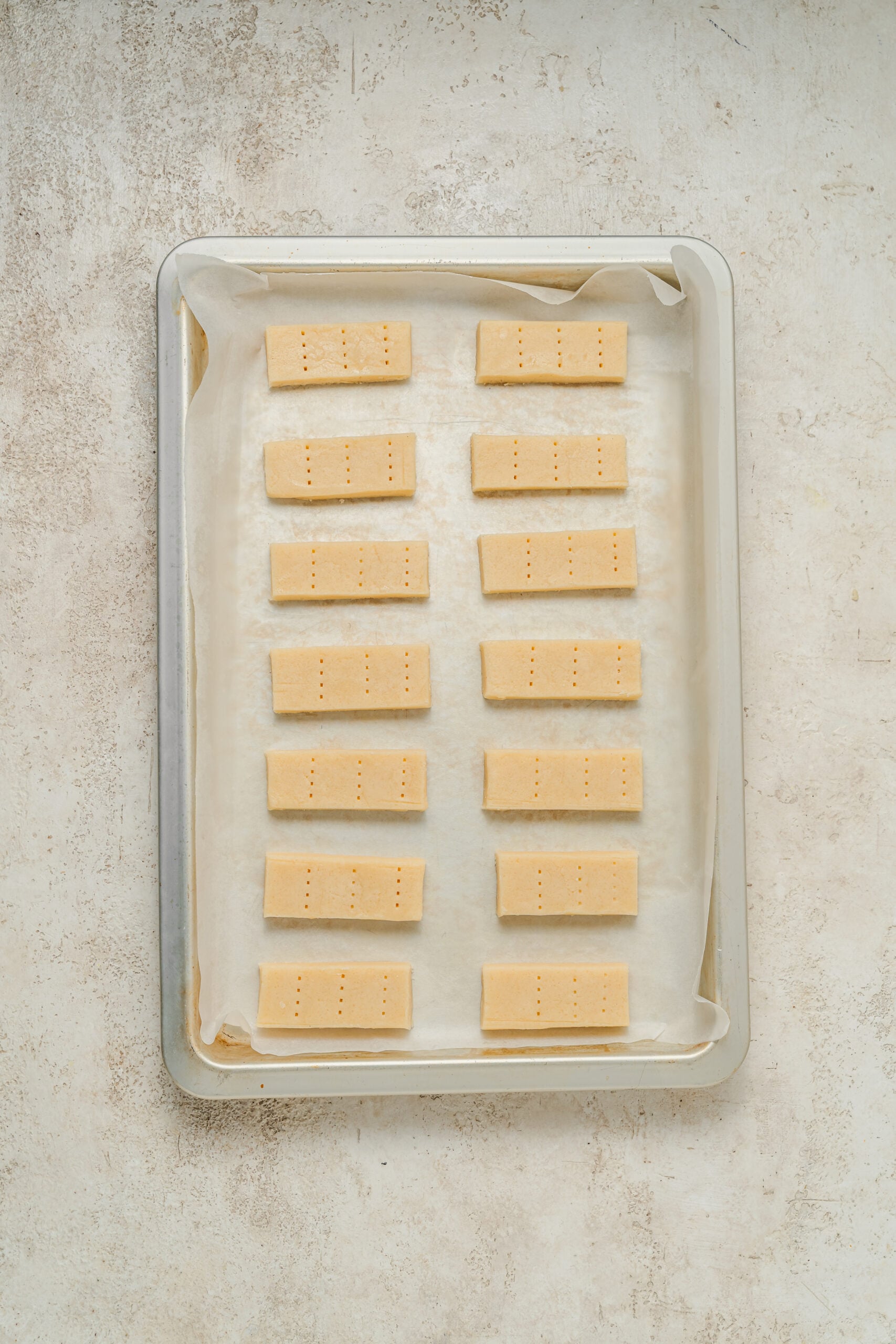 Shortbread fingers docked with a fork and sprinkled with sugar on a lined tray - Catherine Zhang Shortbread fingers docked with a fork and sprinkled with sugar on a lined tray