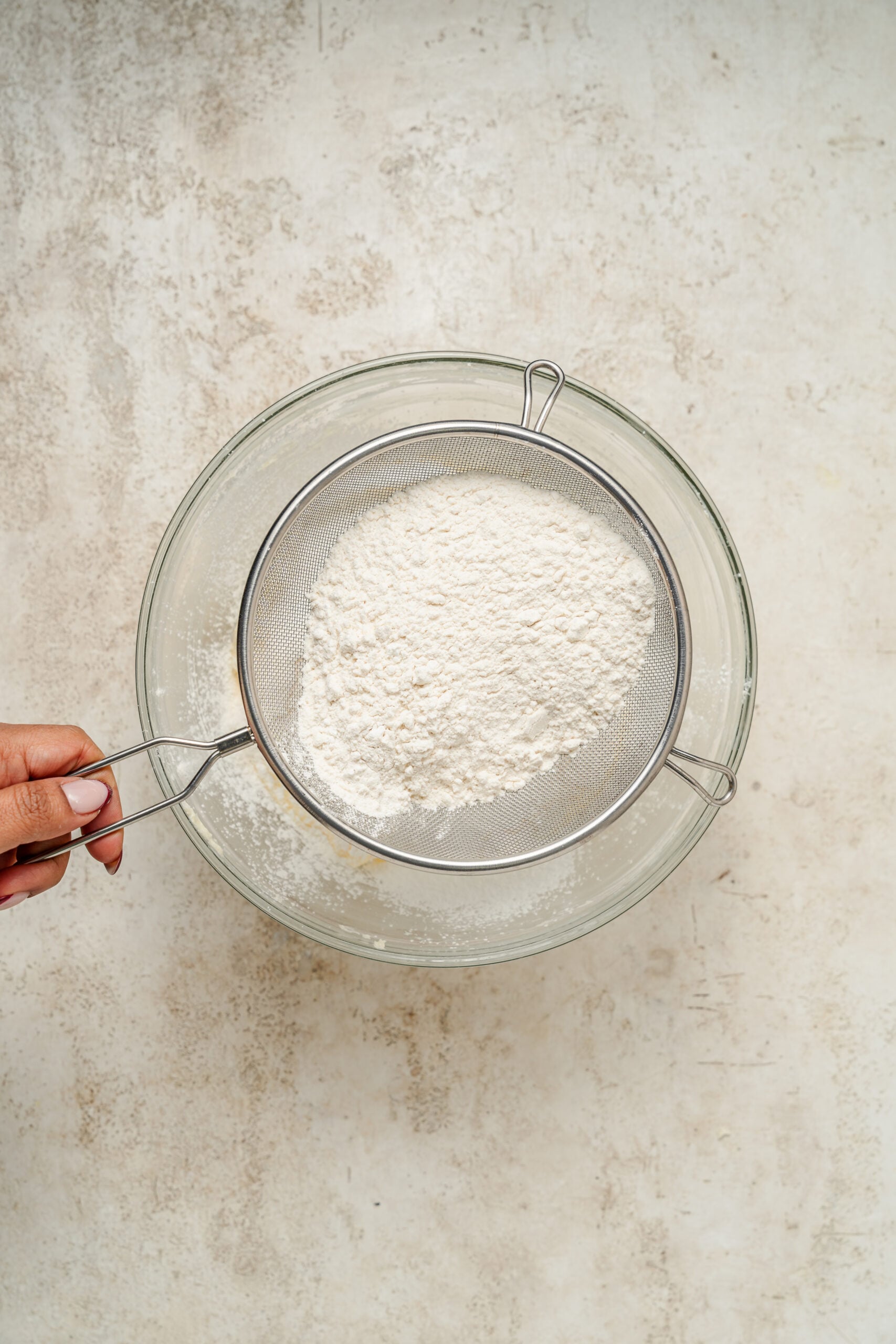 Flour and cornstarch being sifted over the creamed butter - Catherine Zhang Flour and cornstarch being sifted over the creamed butter