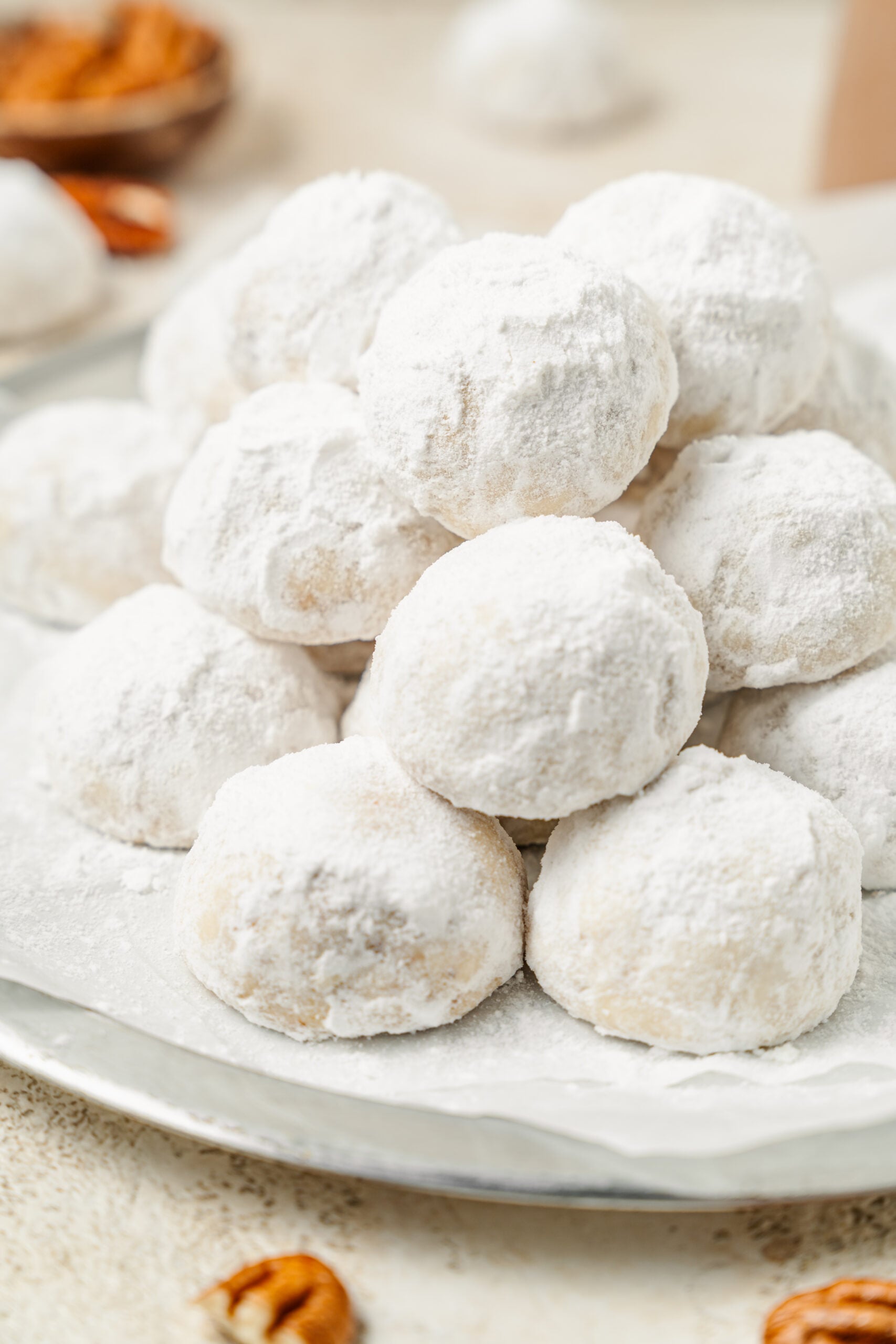 A plate piled with snowball cookies coated in powdered sugar - Catherine Zhang A plate piled with snowball cookies coated in powdered sugar