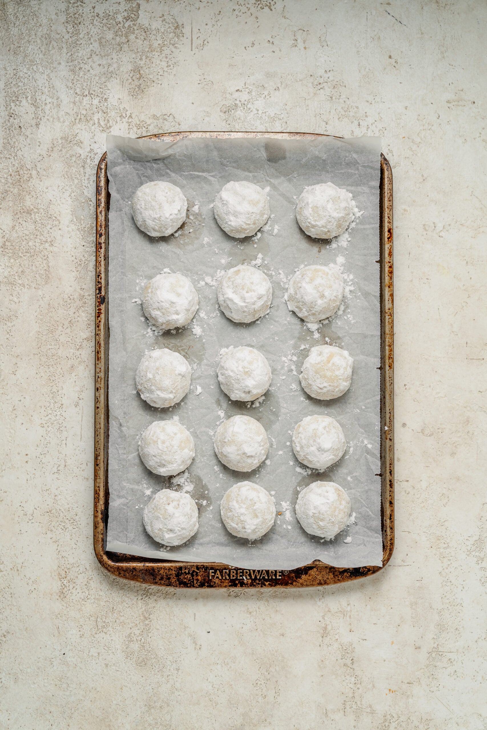 A tray of snowball cookies after the second coat of powdered sugar - Catherine Zhang A tray of snowball cookies after the second coat of powdered sugar
